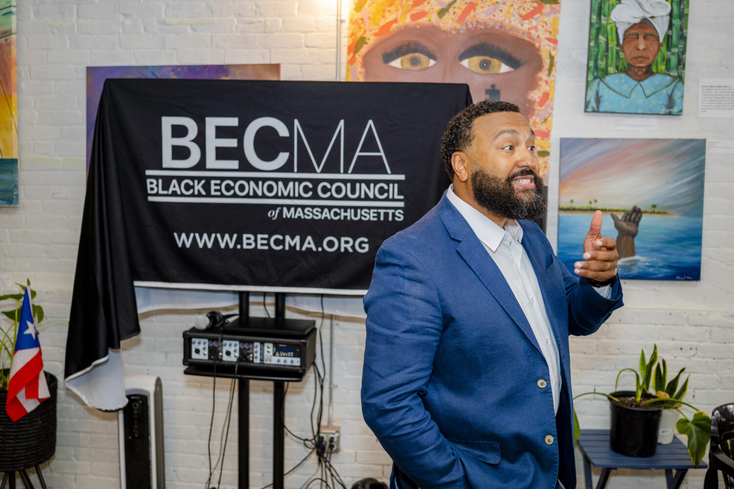 A speaker stands in front of a screen that reads "Black Economic Council of Massachusetts."