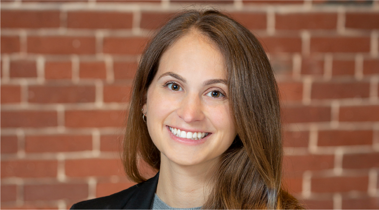 Julie Rosen poses for a headshot. She has brown hair and smiles happily.