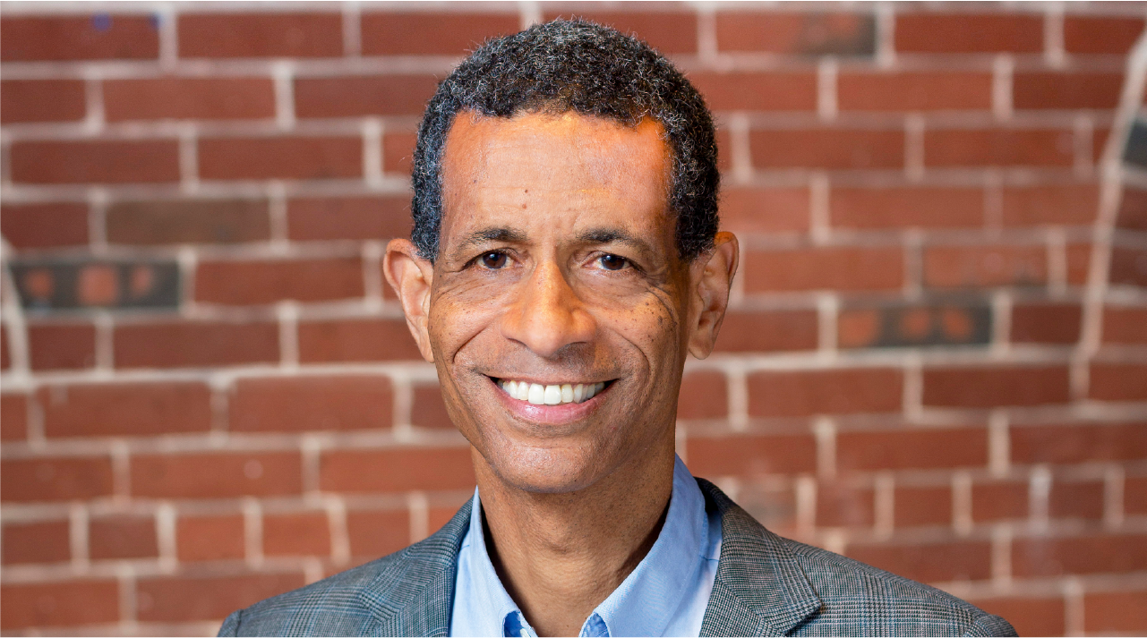 Mark Edwards poses for a headshot. He wears a gray suit.