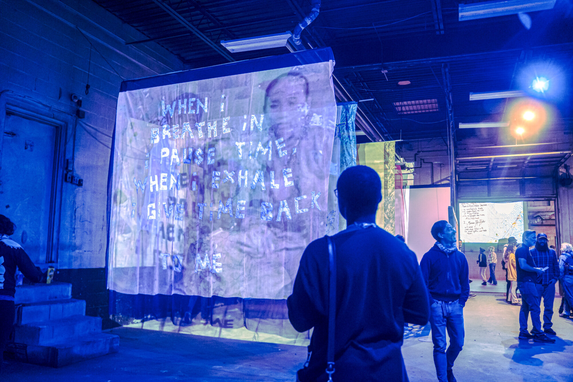 People walk through a large art installation.