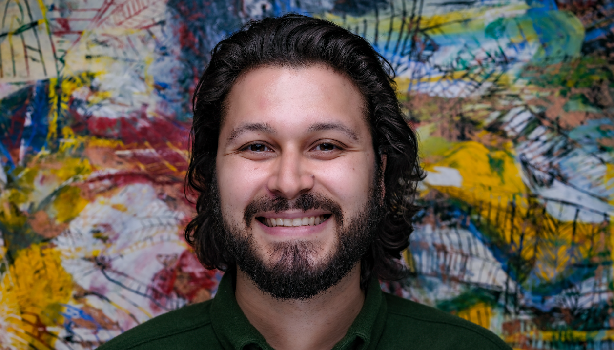 Joe Rodriguez wears a green collared shirt and has dark hair. He smiles warmly.