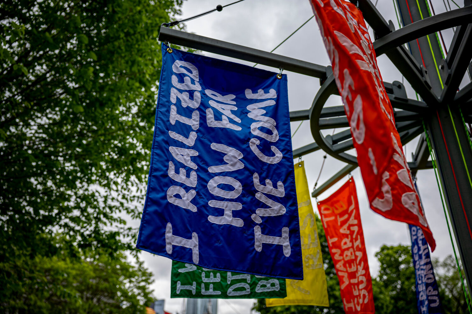 A blue banner with white, sewn on text, reads "I Realized How Far I've Come"