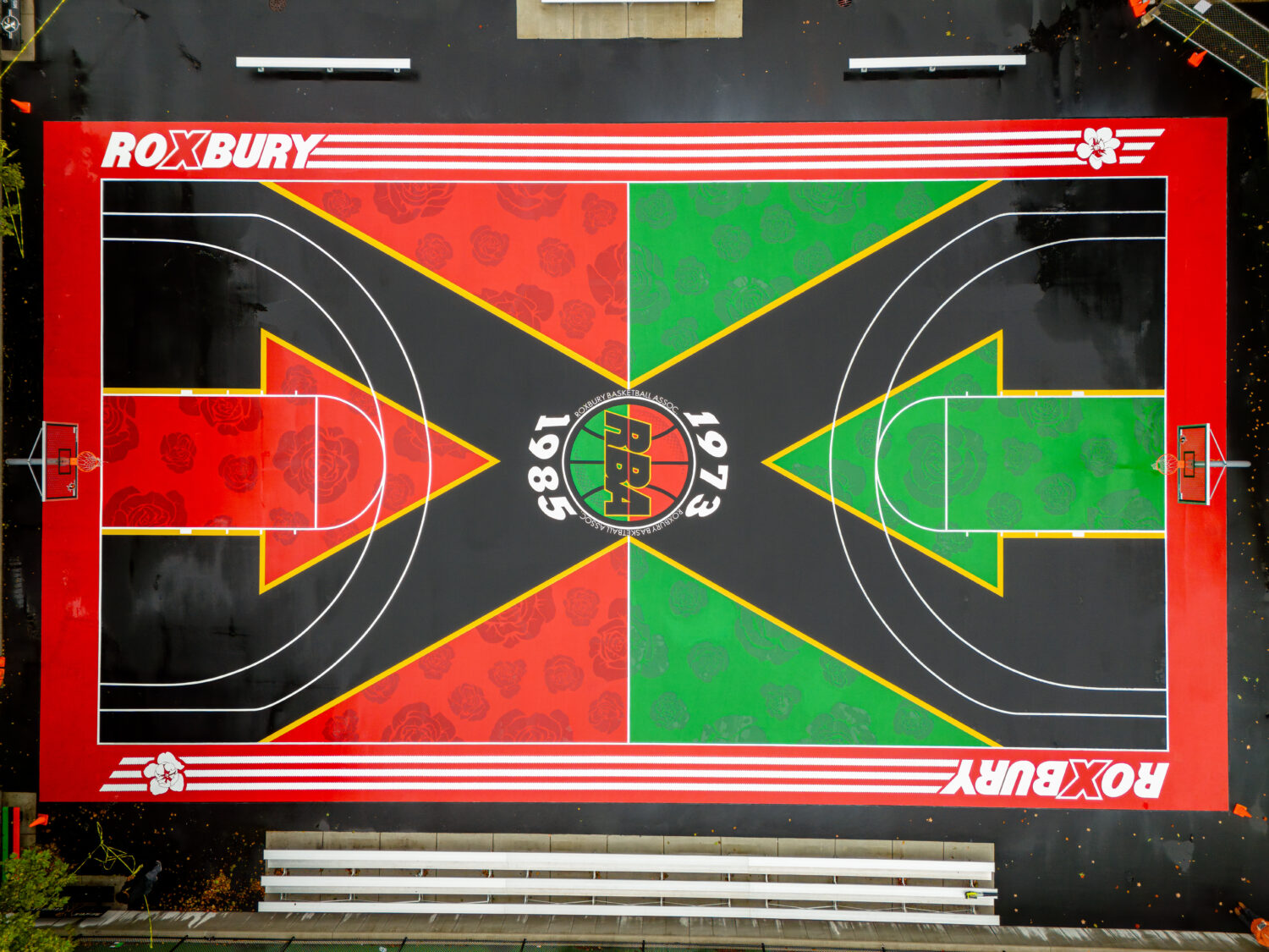 A floral mural painted on a basketball court.