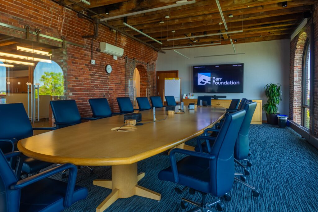 A large conference room with a wooden table and leather chairs.
