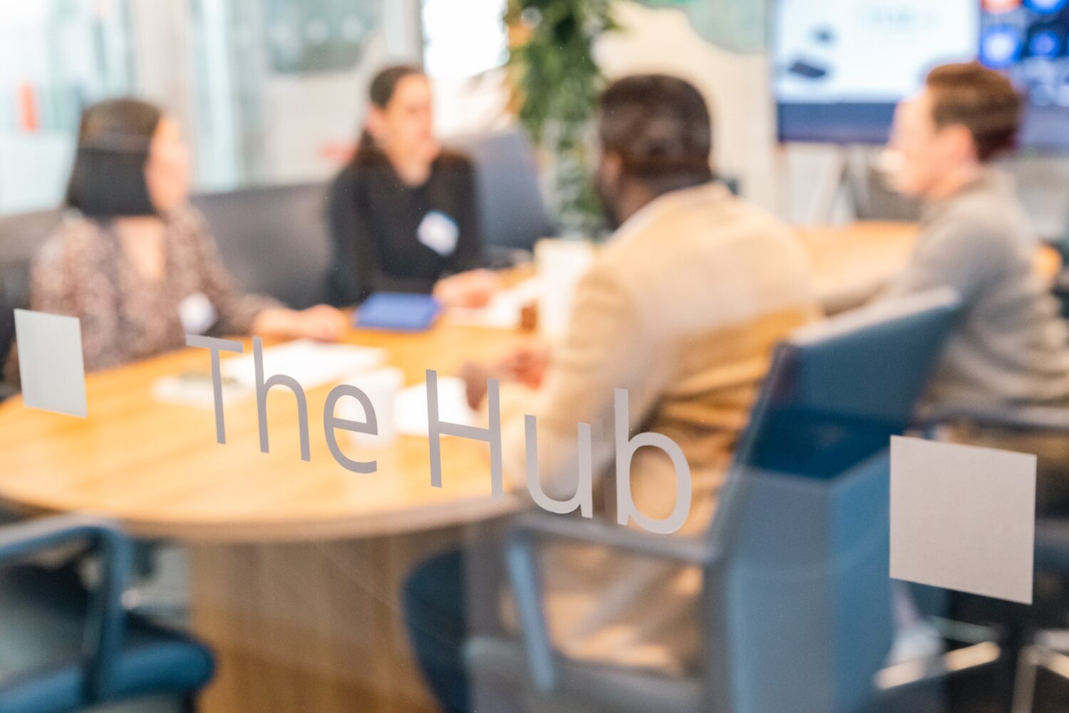 A group meets in a conference room called the Hub.