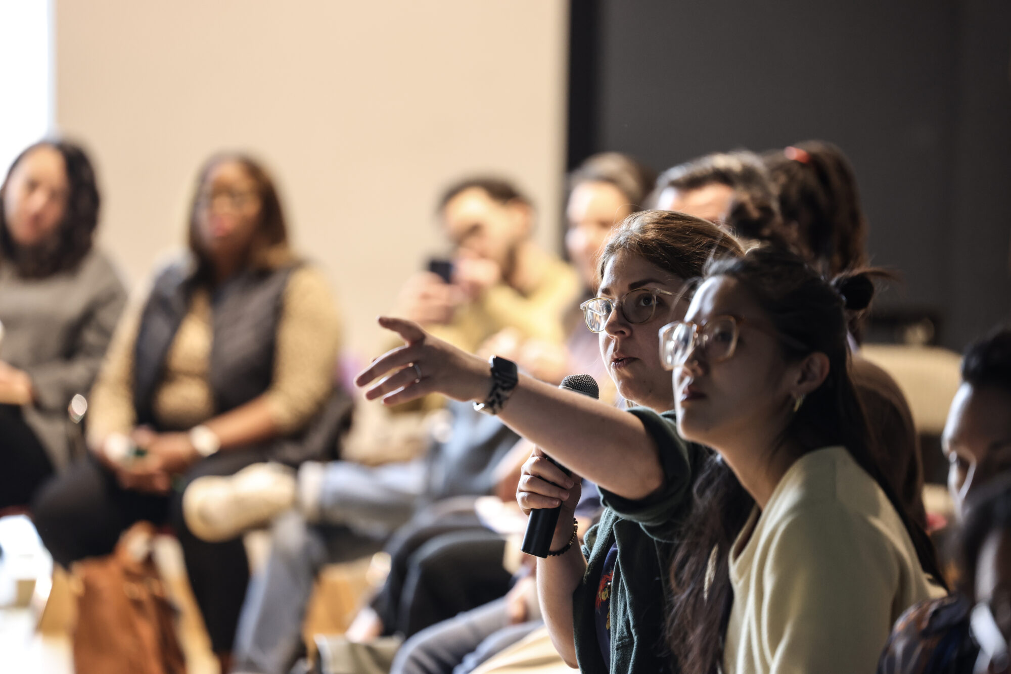 An audience member speaks into a microphone and across the room.