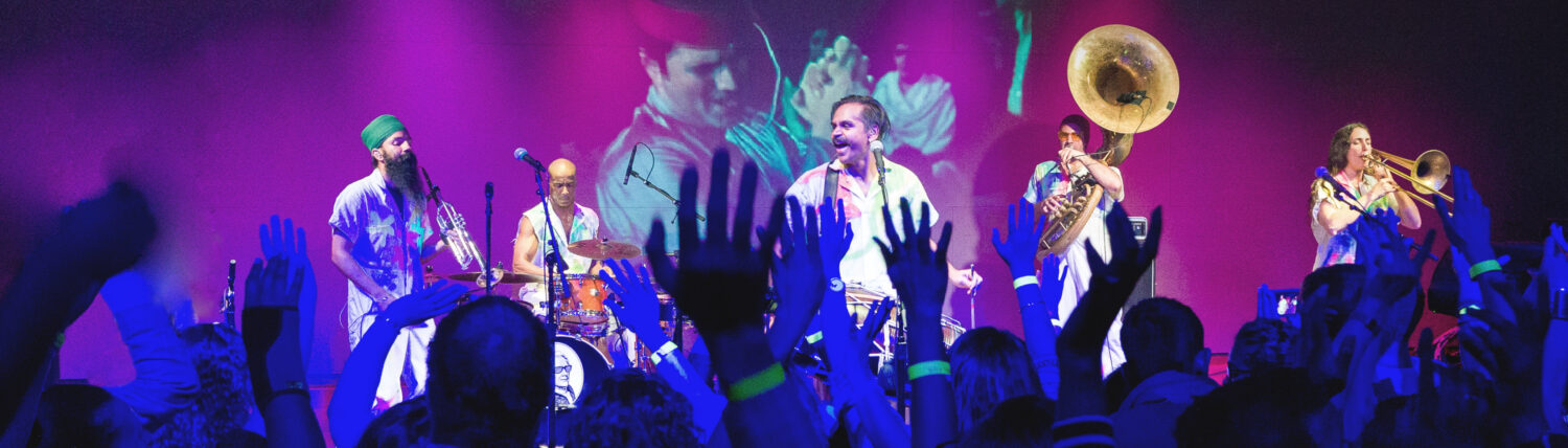 A performance with a large band on stage at Global Arts Live