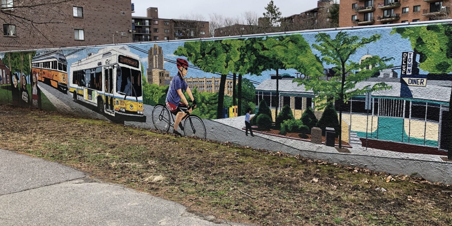 A mural along a sidewalk depicting a public bus, a biker, and a local diner.