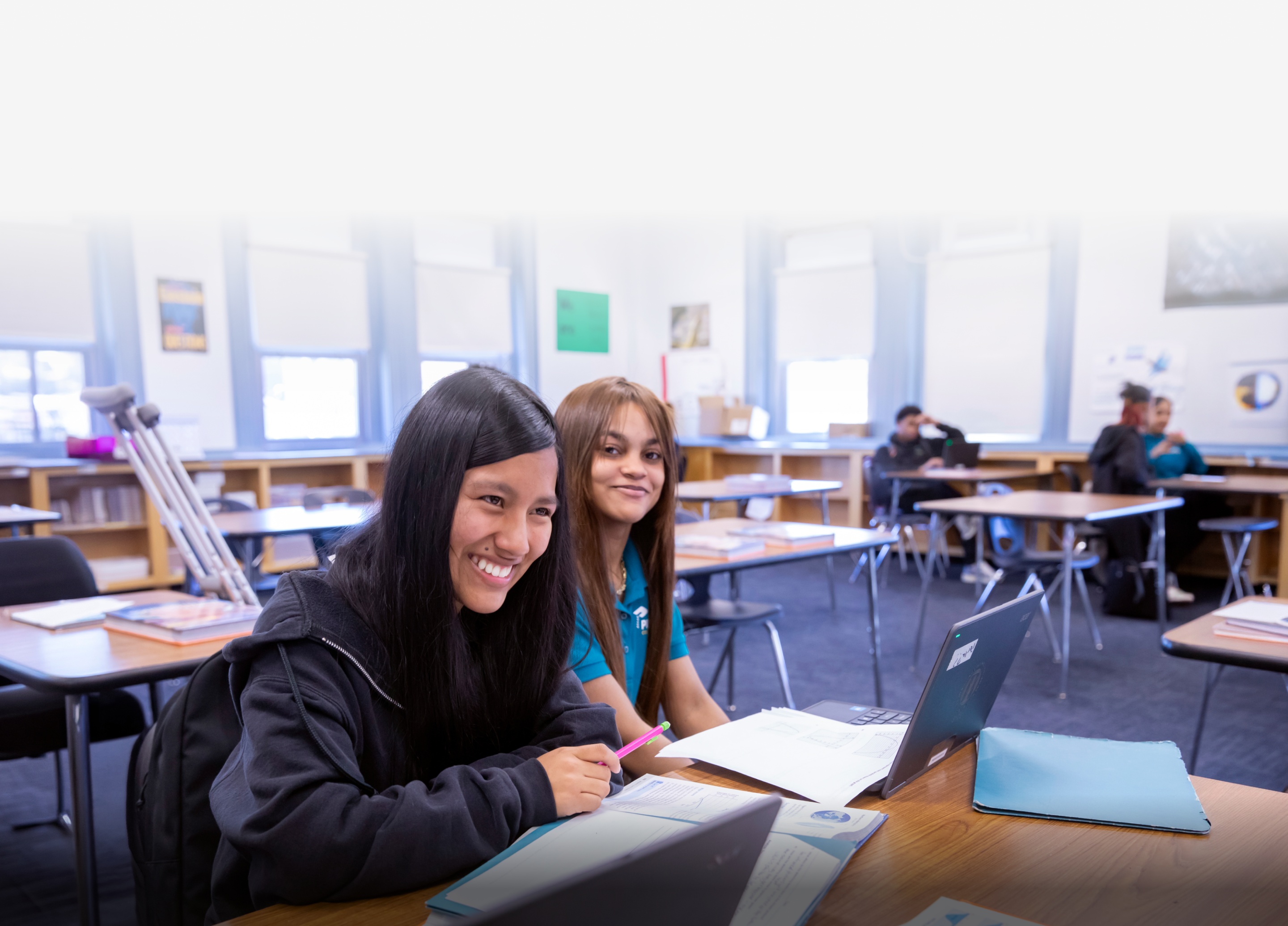 Two girls sitting at a desk at school