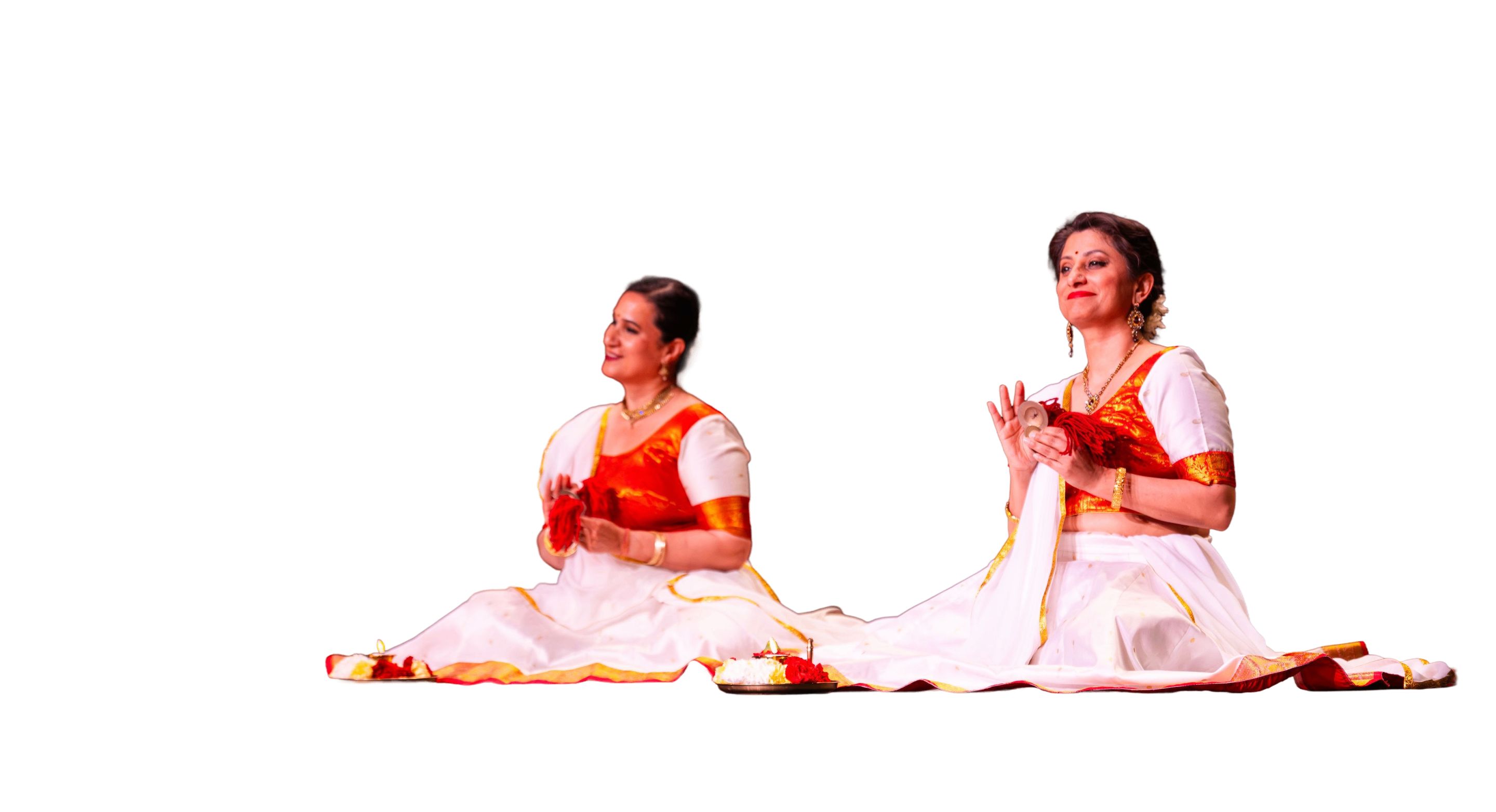 Two women performers sitting on stage