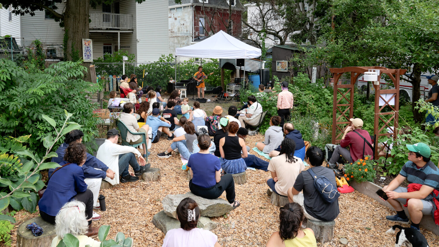 Neighbors gather to listen to music at the Egleston Community Orchard, a small urban garden
